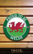 Load image into Gallery viewer, Round sign with red dragon and 'Proud to be Welsh' text on a wooden background