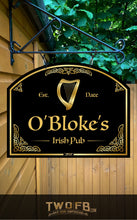 Load image into Gallery viewer, Sign for O&#39;Bloke&#39;s Irish Pub with a harp symbol, hanging against a wooden wall with greenery.
