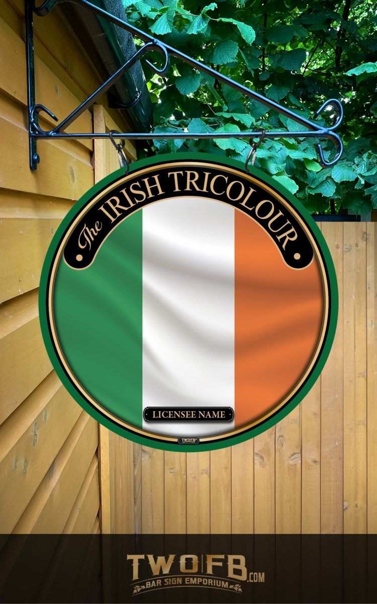 Round sign featuring the Irish Tricolour flag on a wooden wall with greenery above.