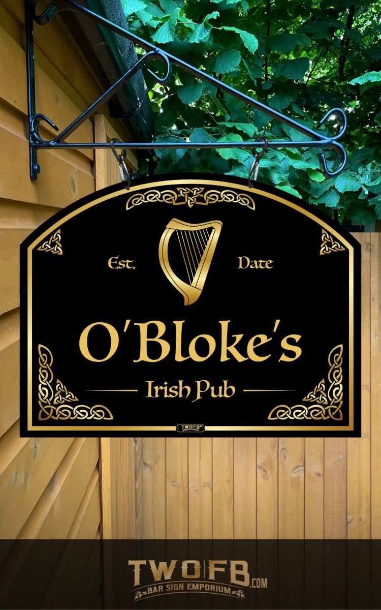Sign for O'Bloke's Irish Pub with a harp symbol, hanging against a wooden wall with greenery.