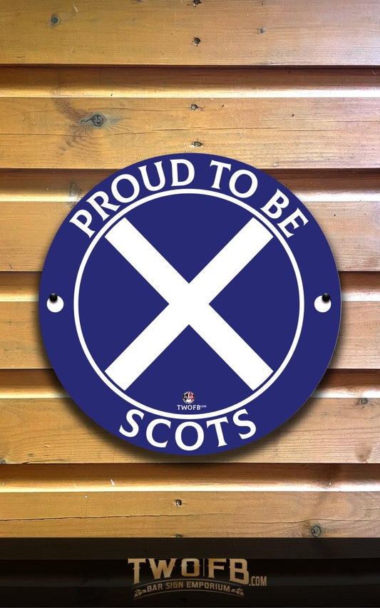 Round blue sign with white cross and text 'Proud to be Scots' on a wooden background