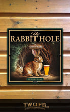 Load image into Gallery viewer, Poster of a rabbit with a beer mug titled &#39;The Rabbit Hole&#39; on a wooden wall.
