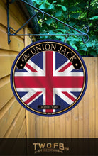 Load image into Gallery viewer, Union Jack sign hanging on a building with greenery in the background

